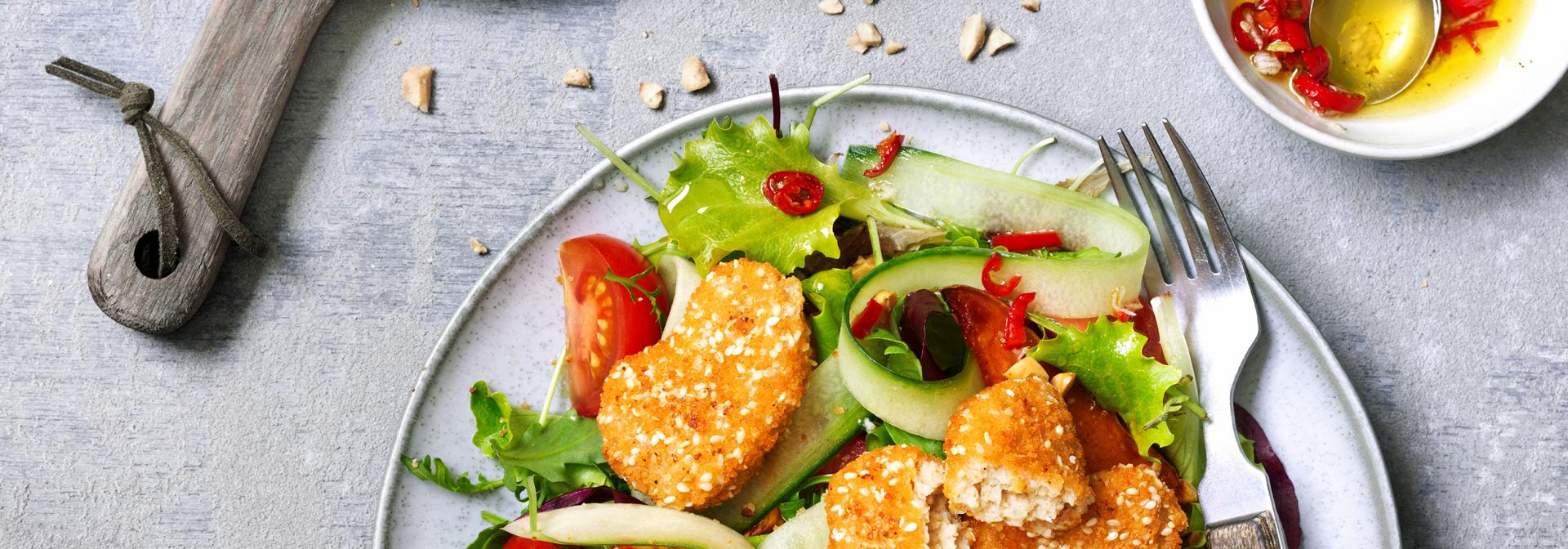 Nuggets con patate dolci arrosto e insalata di pasto con salsa di arachidi