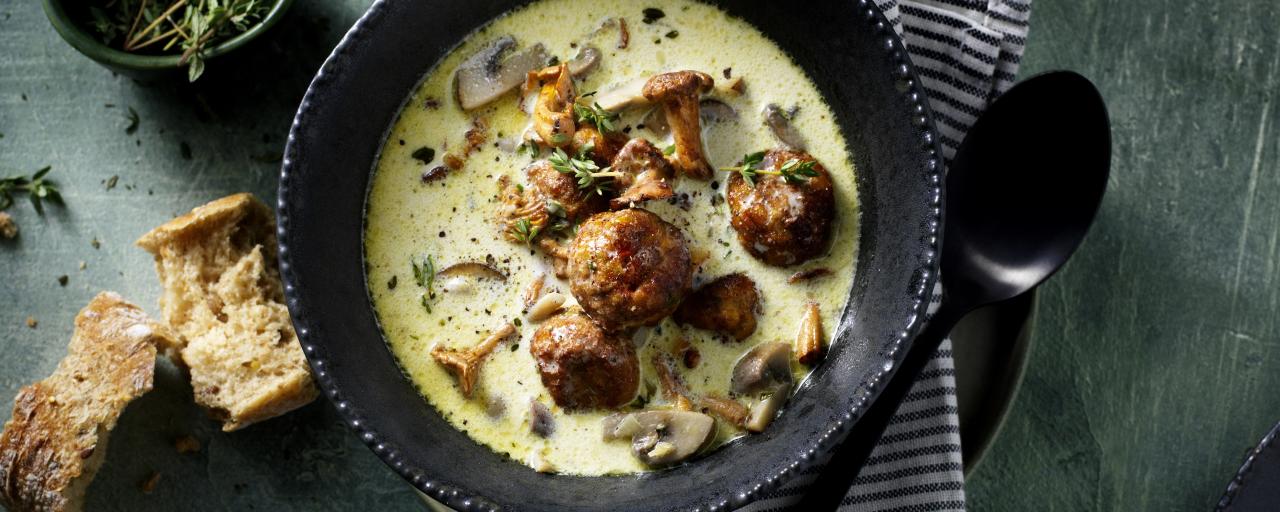 piatto di zuppa di funghi con polpette di verdure su tavola di marmo grigio